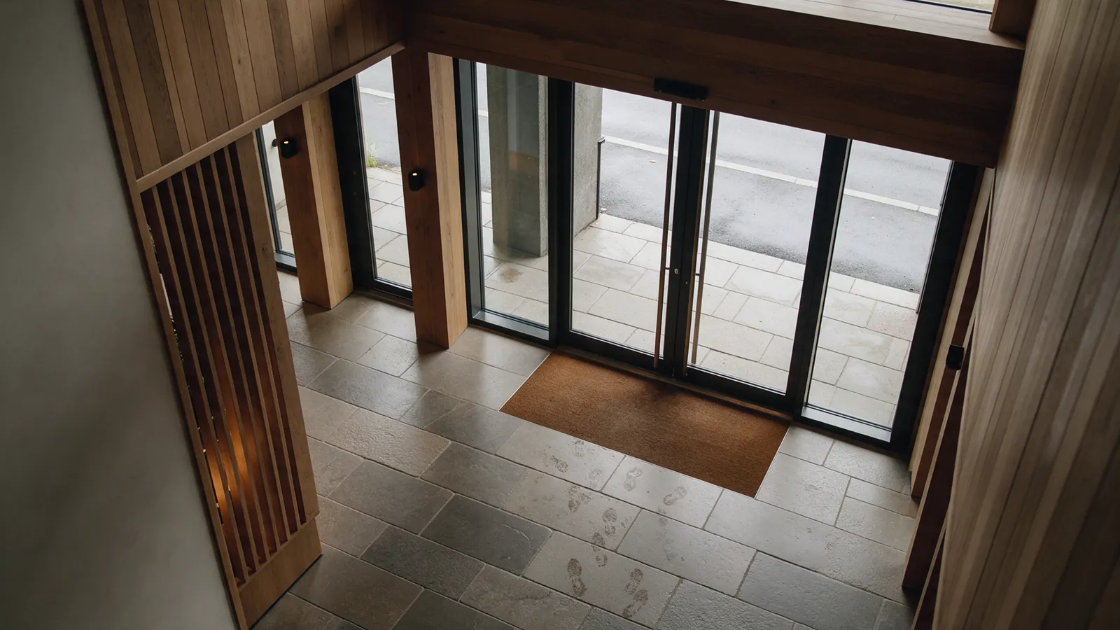 Illustrative hotel entrance corridor with recurring damp marks near the doors.