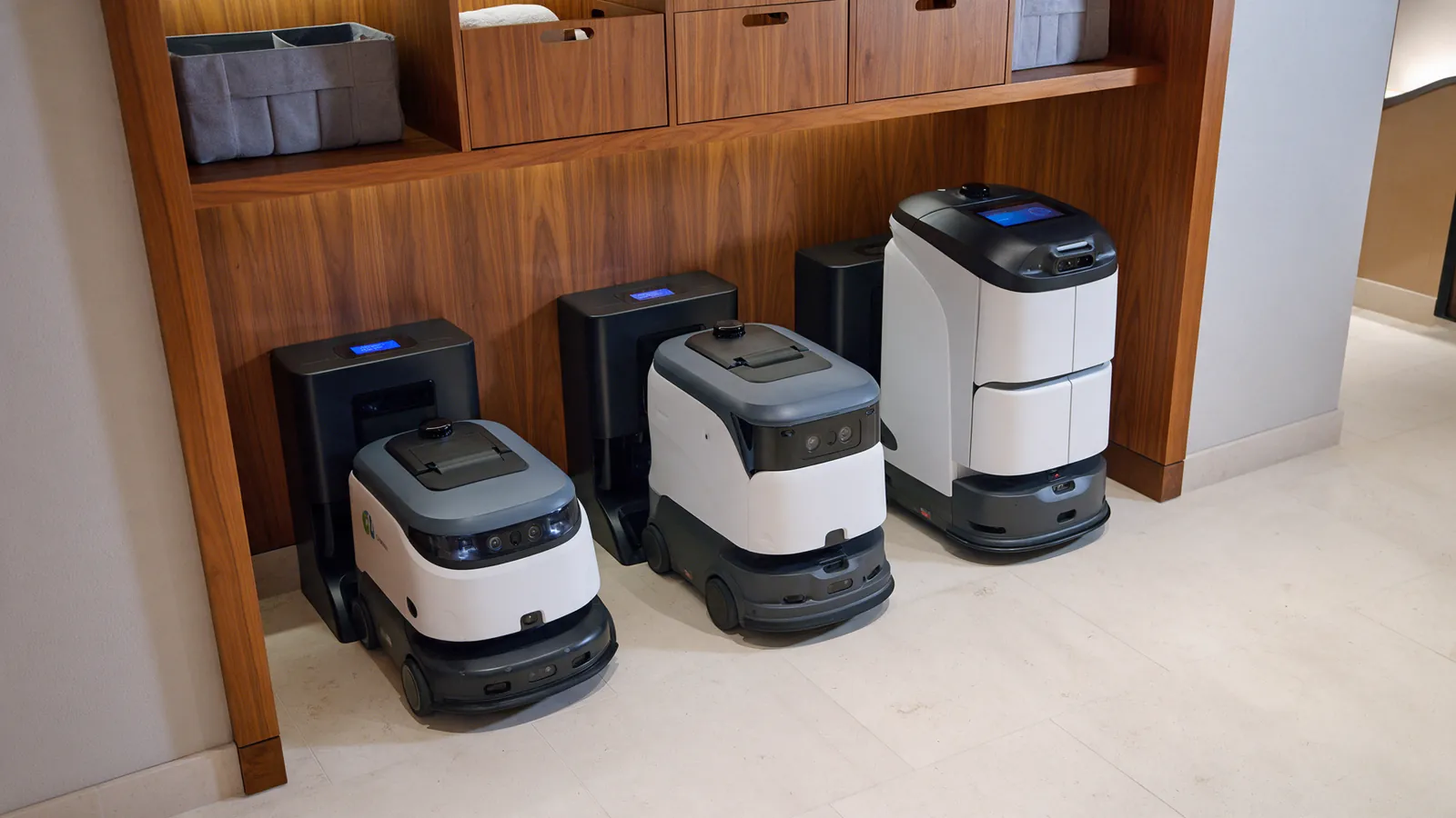 Illustrative fleet of hotel cleaning robots parked in a service bay.