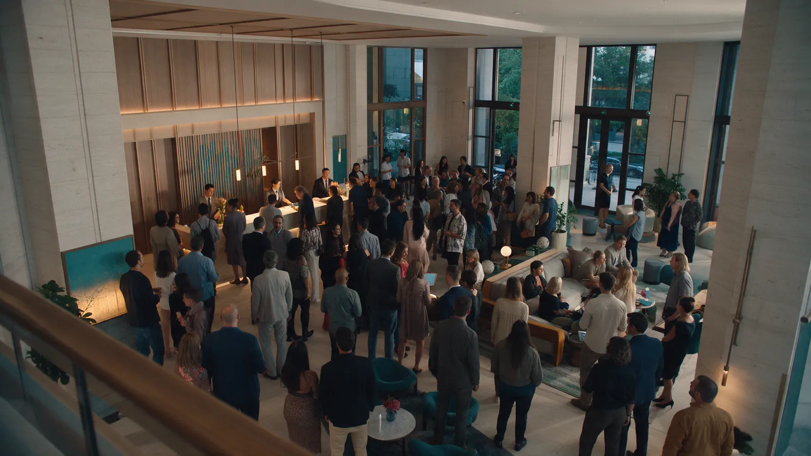 Illustrative hotel lobby with a dense but calm event crowd seen from above.